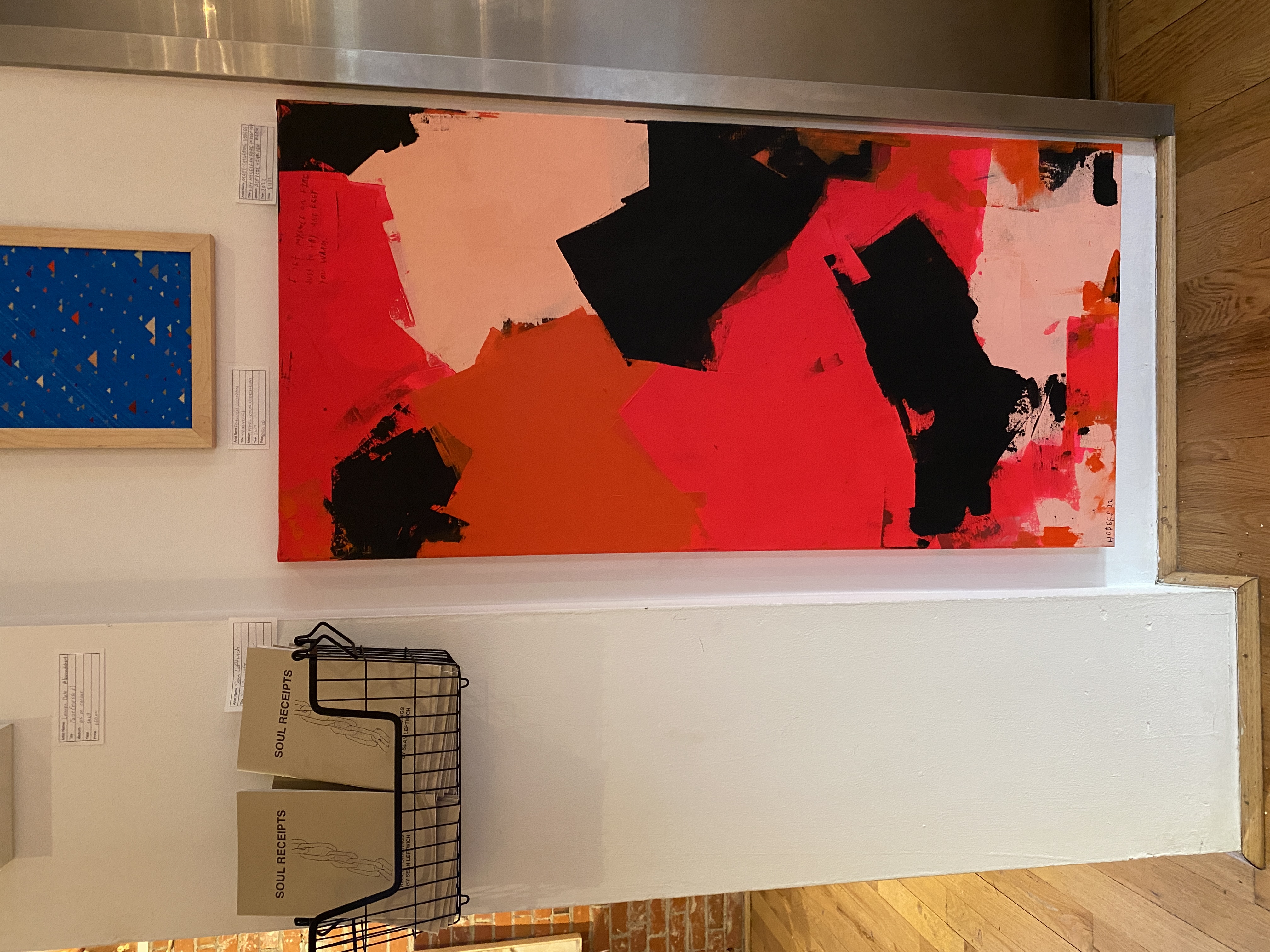 MC's red and black abstract canvas hung on a white gallery wall