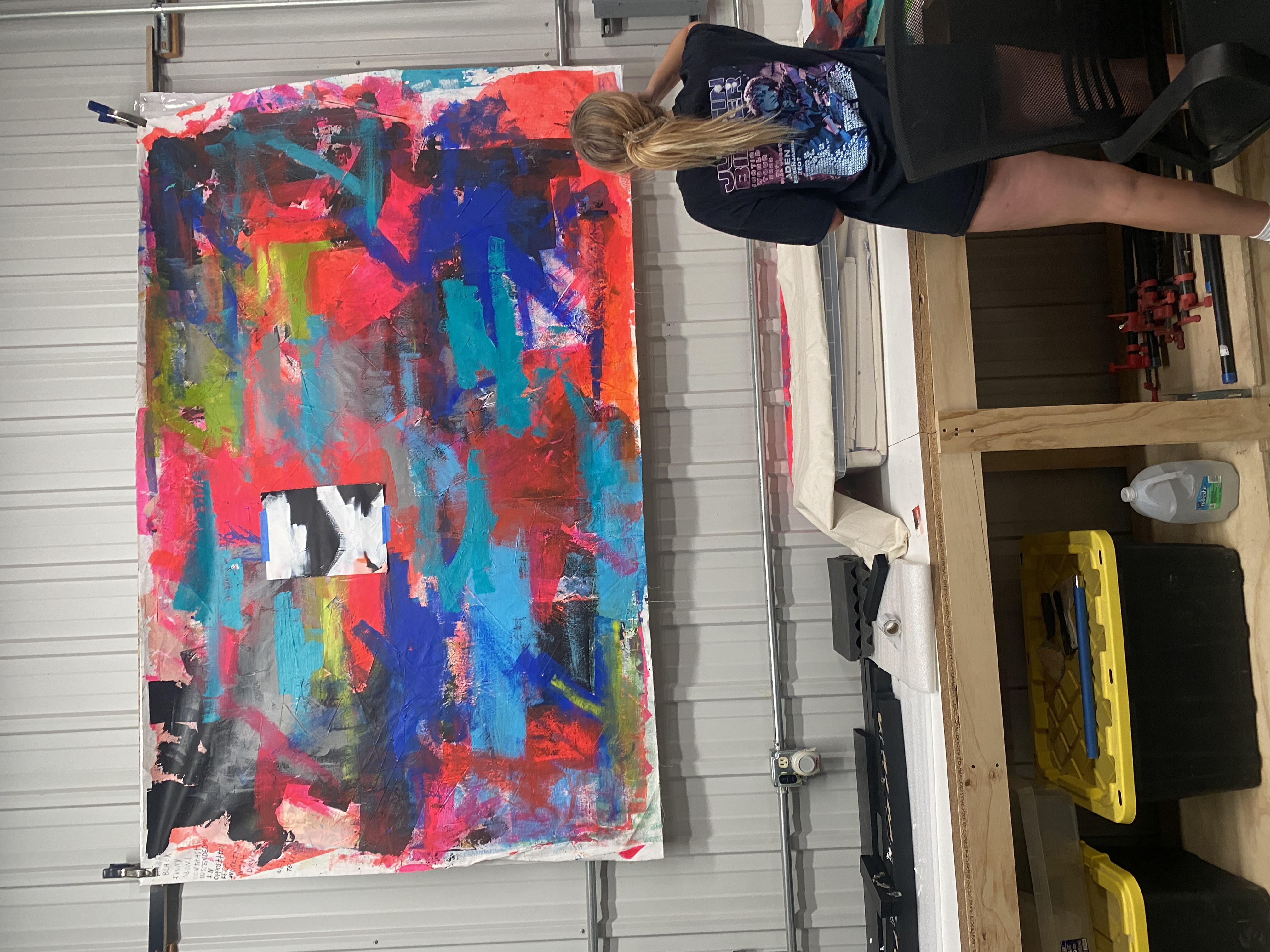 Mary Catherine in her studio next to a large vibrant abstract canvas